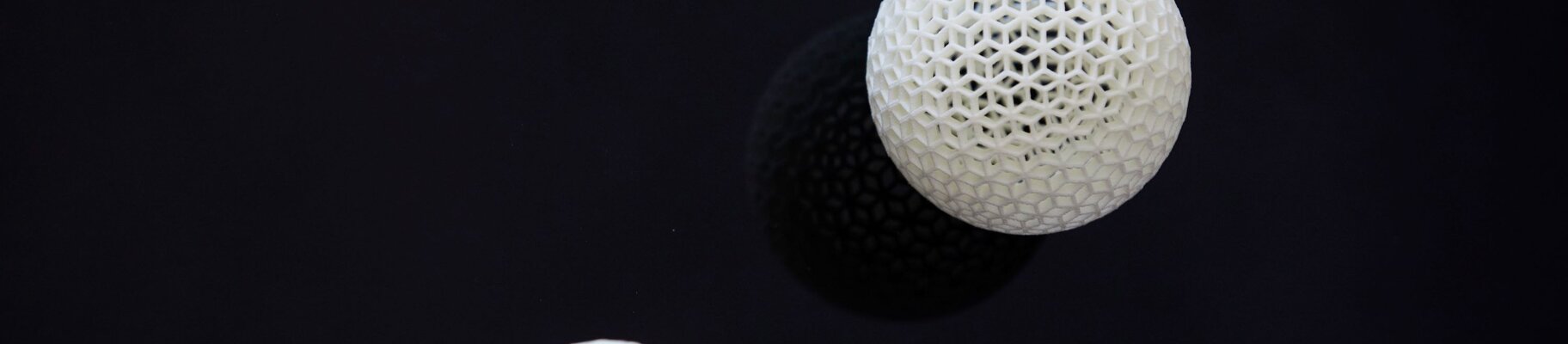 three white 3D printed mesh balls