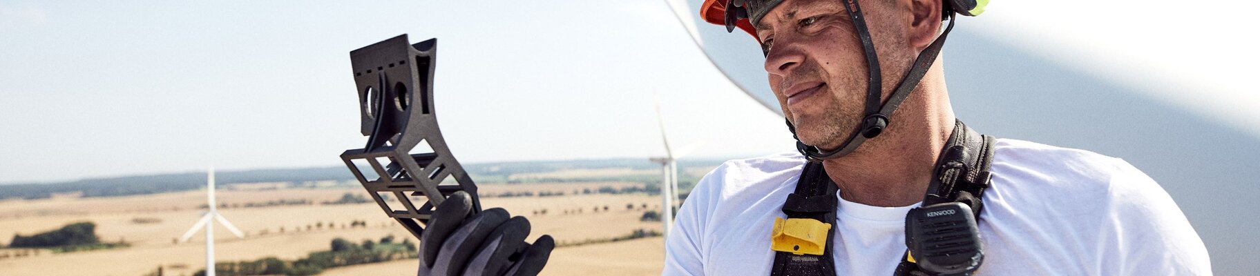 worker replacing spare parts on top of a wind turbine